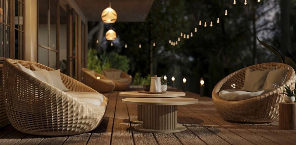 A beautiful deck with round wicker armchairs, outdoor string lights and a nature view at night. landscape lighting